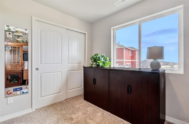 carpeted bedroom with a closet, baseboards, and visible vents
