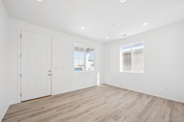 spare room with light hardwood / wood-style floors and a healthy amount of sunlight