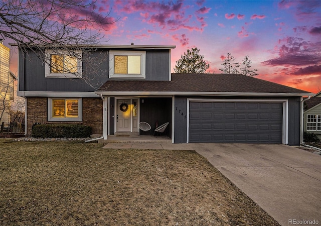 traditional-style house with concrete driveway, an attached garage, brick siding, and a front lawn