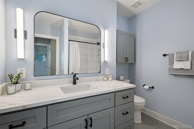 bathroom with vanity, baseboards, visible vents, tile patterned floors, and toilet