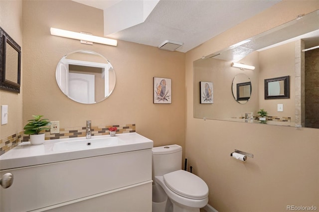 full bath with vanity, toilet, and tasteful backsplash