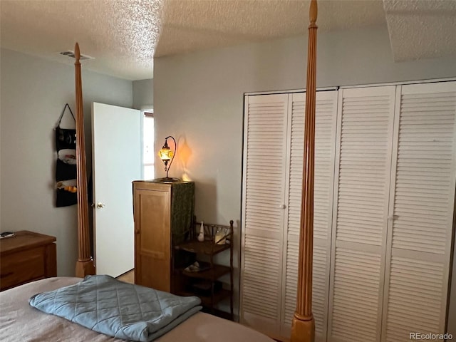 bedroom with a textured ceiling and visible vents
