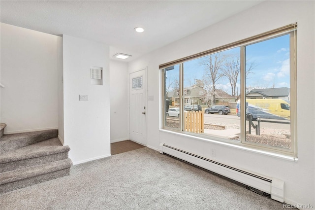 interior space with carpet and a baseboard heating unit