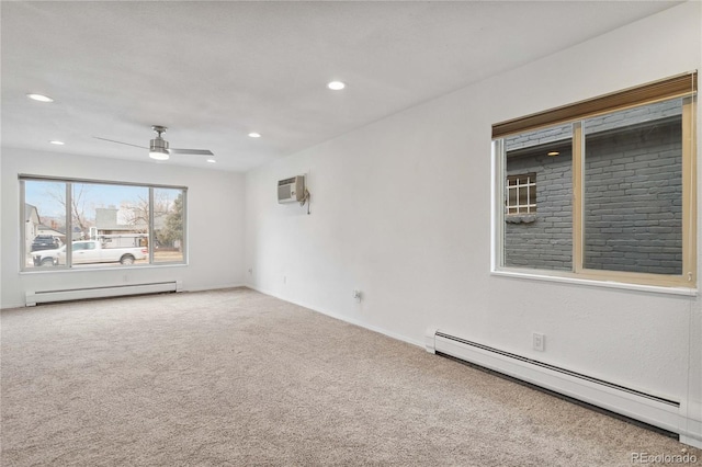 carpeted spare room with ceiling fan, a baseboard radiator, and a wall mounted AC