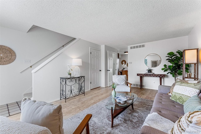 living room with wood-type flooring and a textured ceiling