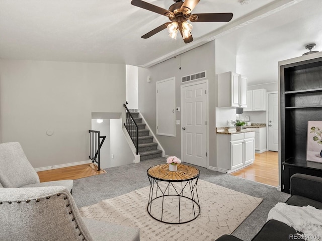 4858 S Quintero Cir, Aurora, CO 80015 - living room with light carpet, ceiling fan, baseboards, and stairs
