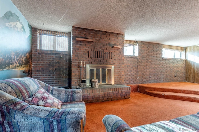 carpeted living room with a fireplace, brick wall, and a textured ceiling