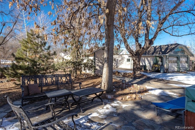 snow covered patio with an outbuilding