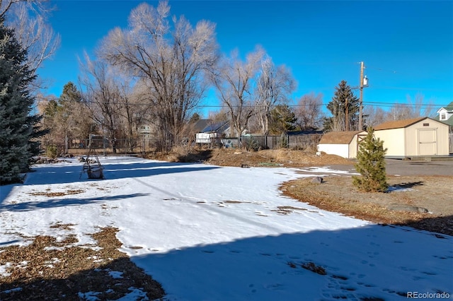 snowy yard with a storage shed