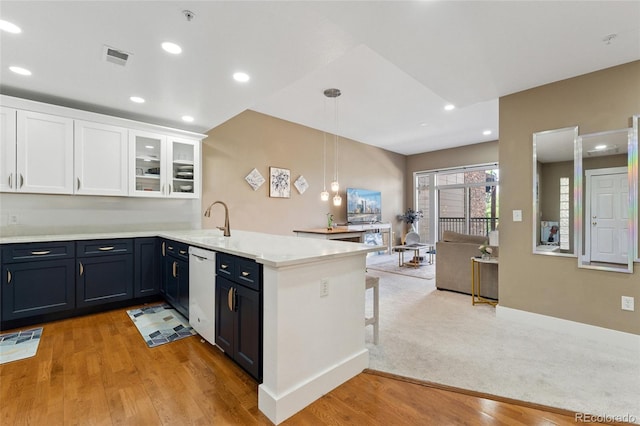 6000 W Floyd Ave Unit 214, Denver, CO 80227 - kitchen with a peninsula, white cabinets, white dishwasher, hanging light fixtures, and light countertops