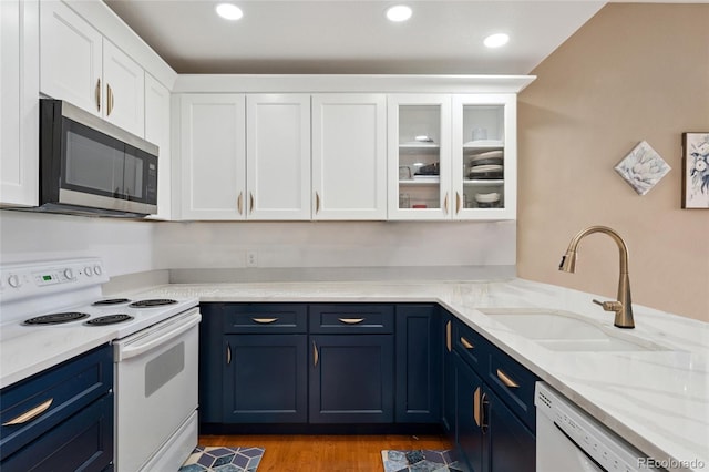 6000 W Floyd Ave Unit 214, Denver, CO 80227 - kitchen with white appliances, blue cabinets, white cabinets, glass insert cabinets, and light stone counters