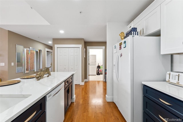 6000 W Floyd Ave Unit 214, Denver, CO 80227 - kitchen featuring white appliances, white cabinets, recessed lighting, light wood finished floors, and light stone countertops