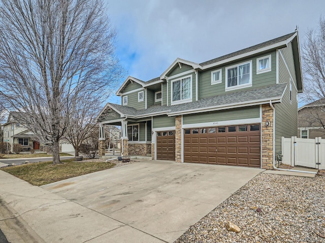 craftsman inspired home featuring a garage, stone siding, driveway, and a shingled roof