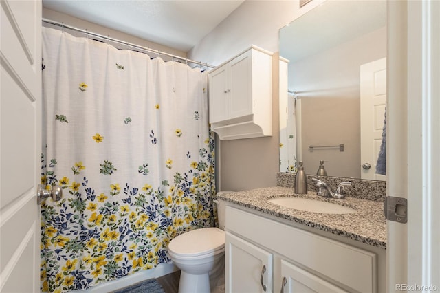 bathroom featuring curtained shower, vanity, and toilet