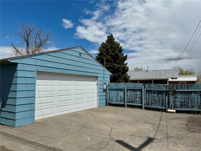 detached garage featuring fence