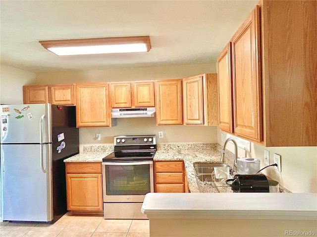 kitchen featuring light tile patterned flooring, a sink, light brown cabinets, stainless steel appliances, and under cabinet range hood