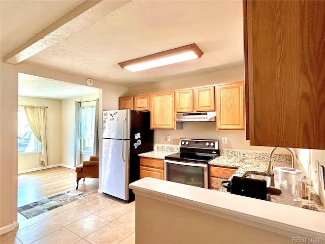kitchen featuring light brown cabinets, light countertops, under cabinet range hood, appliances with stainless steel finishes, and light tile patterned floors