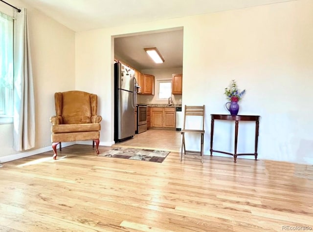 sitting room featuring baseboards and light wood finished floors