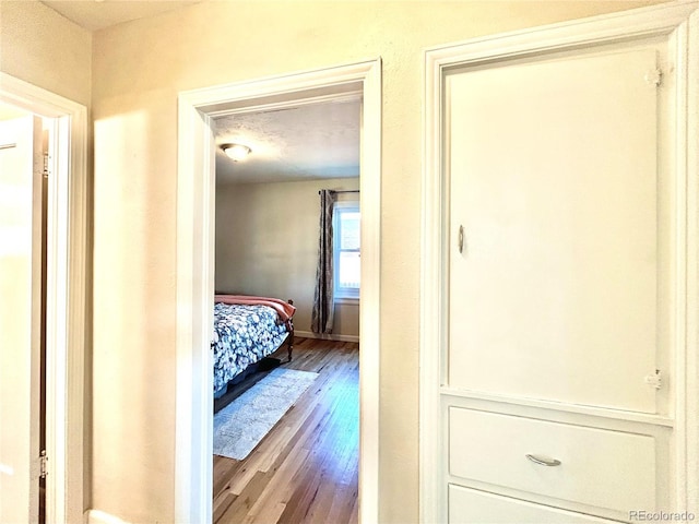bedroom featuring baseboards and wood finished floors