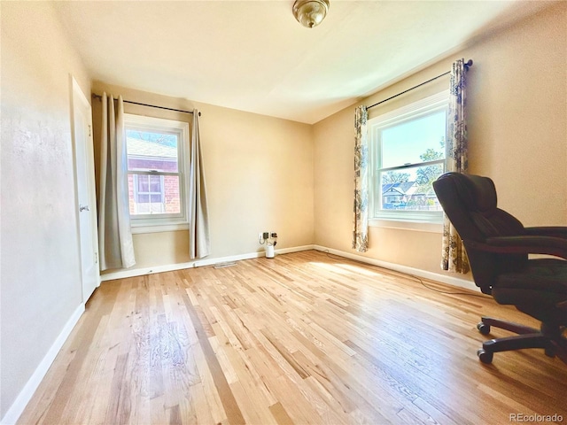 office space with baseboards and wood finished floors
