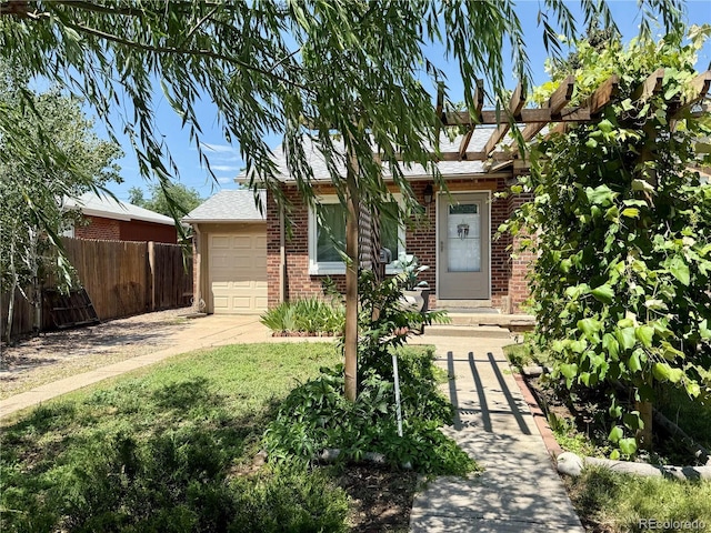 1965 Havana St, Aurora, CO 80010 - view of property hidden behind natural elements featuring brick siding, an attached garage, concrete driveway, and roof with shingles