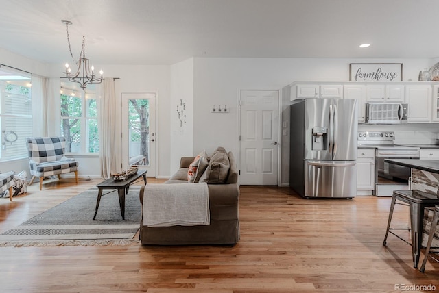 8367 Devinney St, Arvada, CO 80005 - living room with a chandelier, light wood-style floors, and recessed lighting
