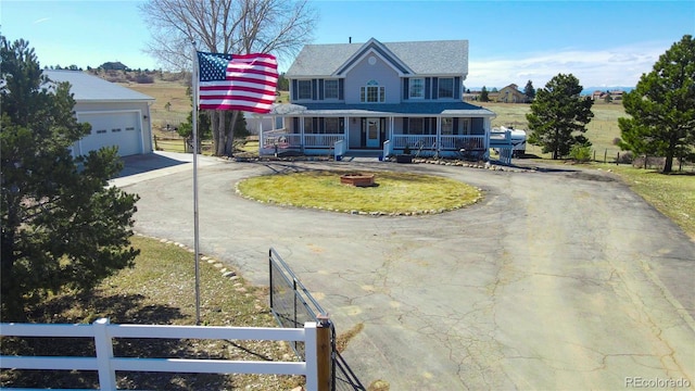 view of front facade featuring a garage, covered porch, curved driveway, and fence