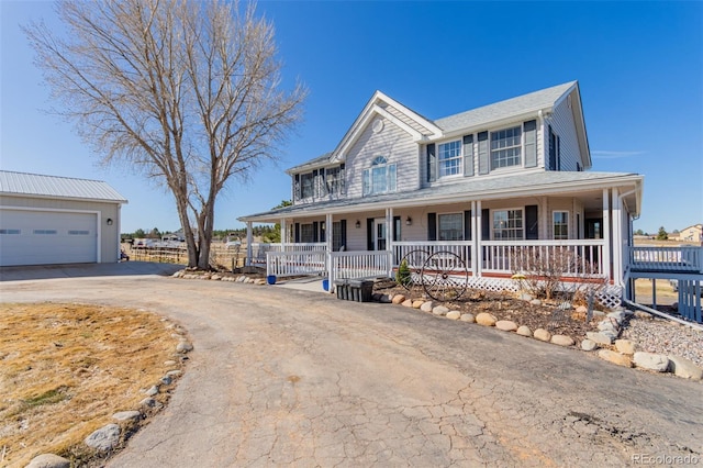 view of front of home with a porch, an outbuilding, a garage, and driveway