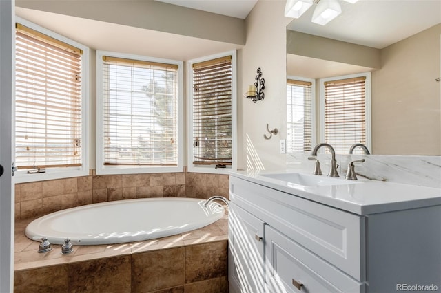 full bath featuring a wealth of natural light, vanity, and a garden tub