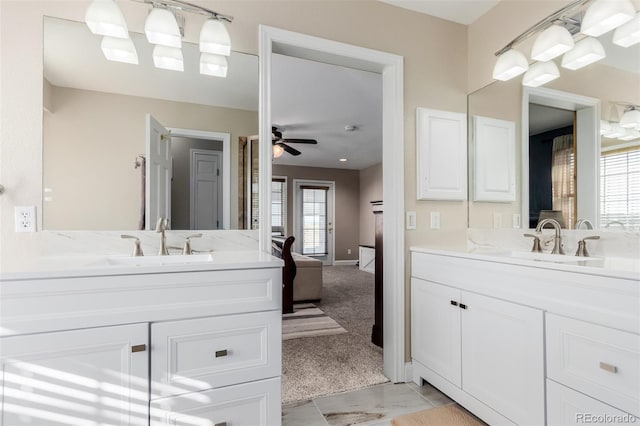 bathroom featuring ensuite bath, two vanities, a ceiling fan, and a sink