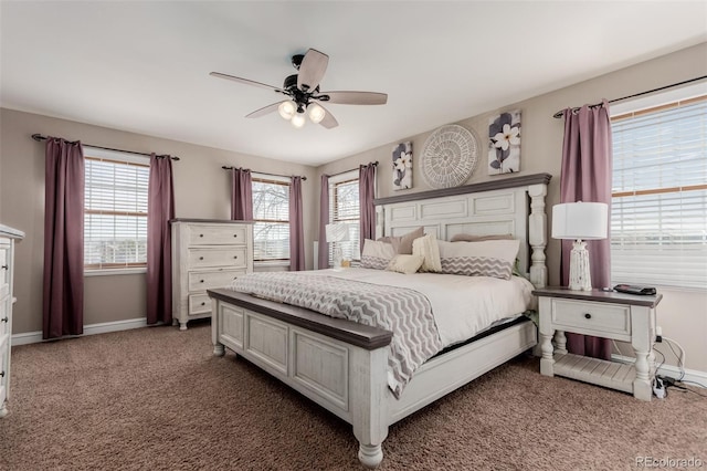 carpeted bedroom featuring multiple windows, a ceiling fan, and baseboards