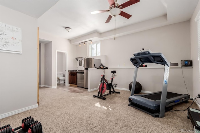 workout area with light carpet, baseboards, ceiling fan, and a sink