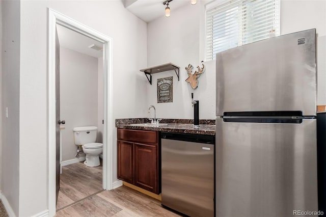 bathroom featuring visible vents, baseboards, toilet, wood finished floors, and vanity