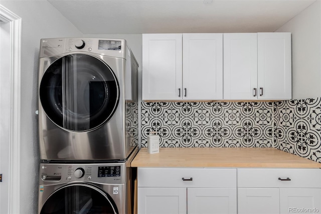 laundry room with cabinet space and stacked washing maching and dryer