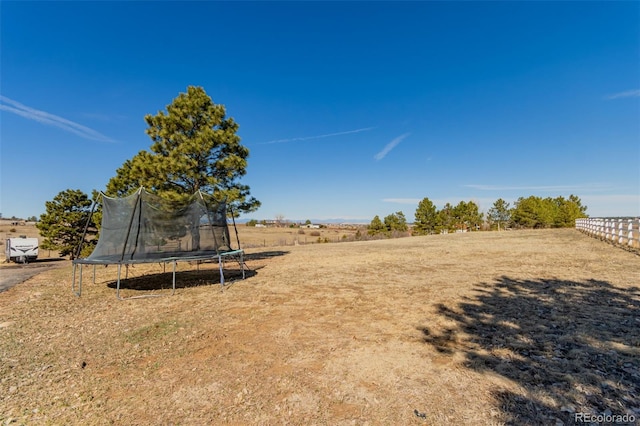 view of yard with a trampoline and a rural view