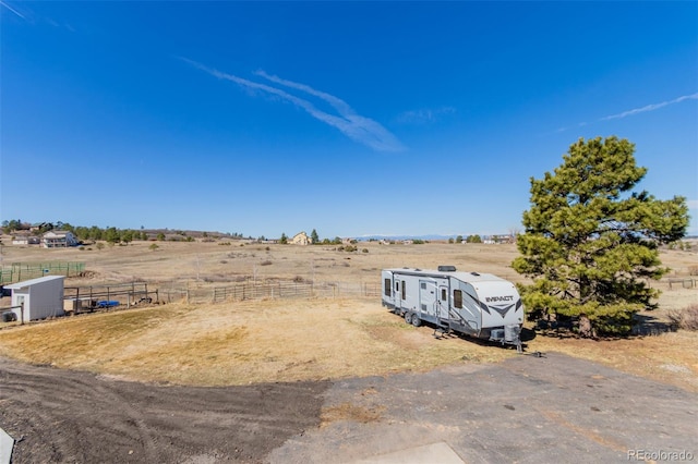 view of yard featuring a rural view and fence