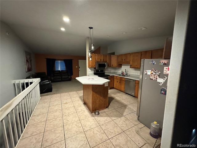 kitchen featuring stainless steel appliances, sink, decorative light fixtures, a kitchen island, and vaulted ceiling