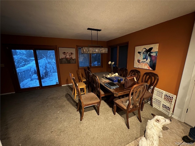 carpeted dining space with a textured ceiling