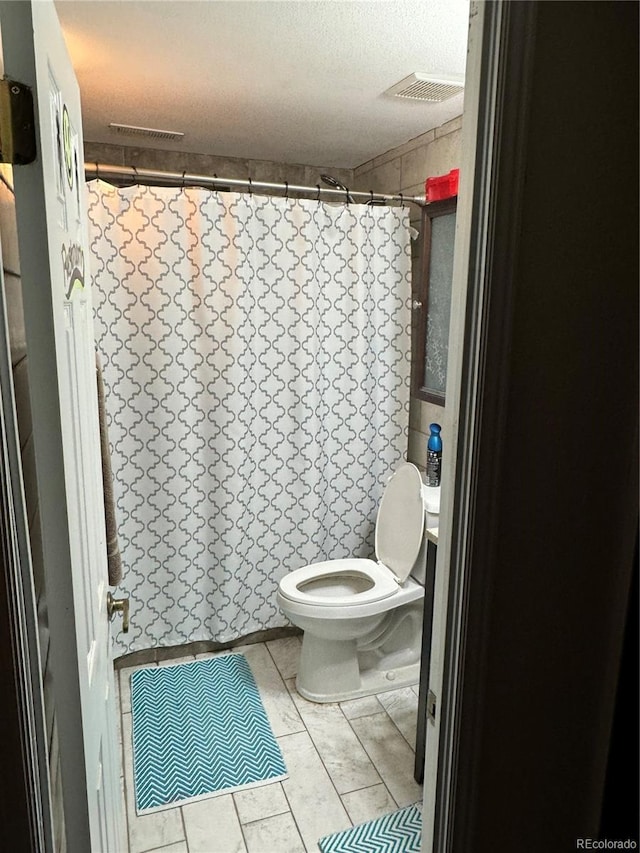 bathroom featuring a textured ceiling and toilet