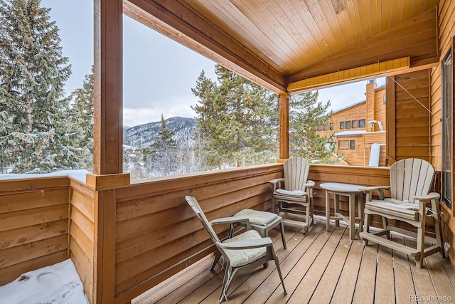 snow covered back of property with a mountain view