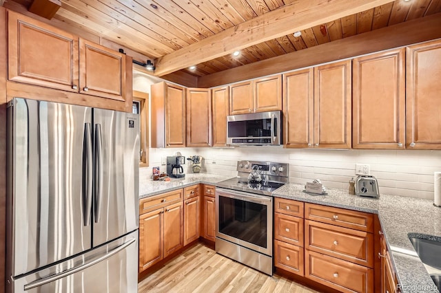 kitchen with light wood-type flooring, appliances with stainless steel finishes, beamed ceiling, light stone counters, and wood ceiling