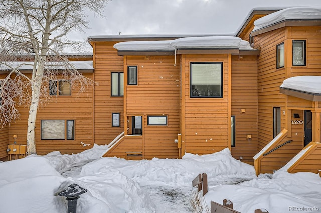 view of snow covered rear of property