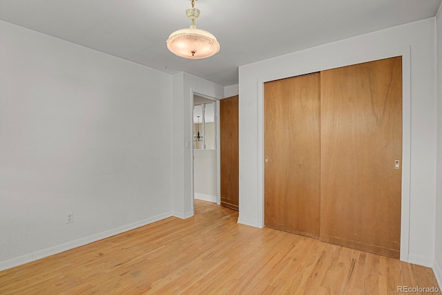 unfurnished bedroom with light hardwood / wood-style floors and a closet