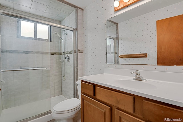 bathroom featuring vanity, toilet, and an enclosed shower