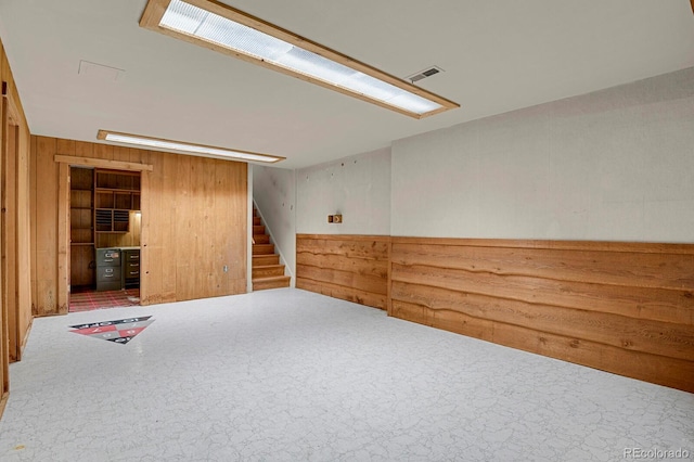 spare room with carpet flooring and wooden walls