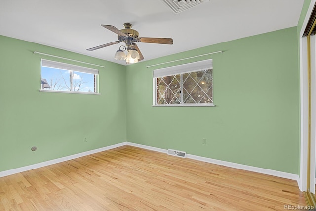 empty room with ceiling fan and light hardwood / wood-style flooring