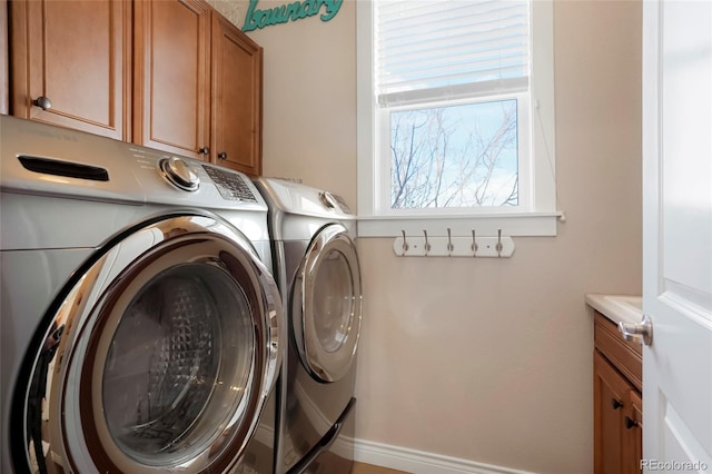clothes washing area with cabinet space and independent washer and dryer