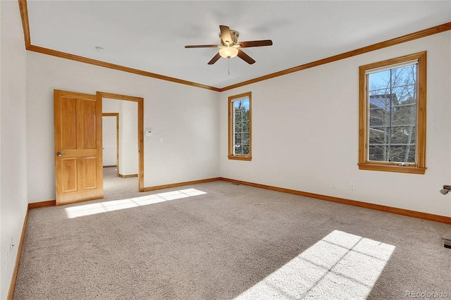 unfurnished room with crown molding, light carpet, plenty of natural light, and baseboards