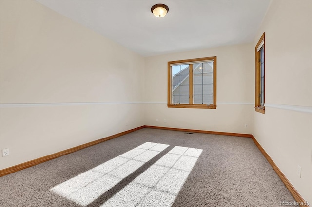 carpeted empty room with baseboards