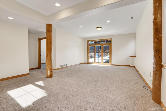 spare room featuring light colored carpet, visible vents, and baseboards